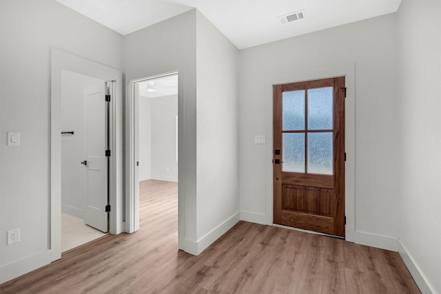 foyer entrance featuring light wood finished floors, baseboards, and visible vents