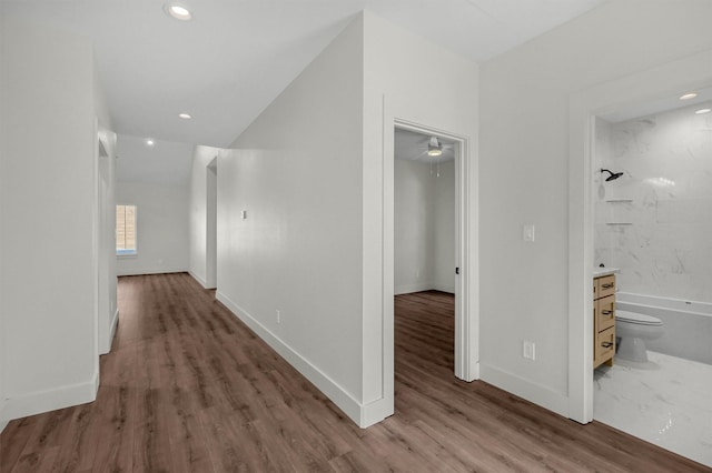 corridor with dark wood-style flooring, recessed lighting, and baseboards