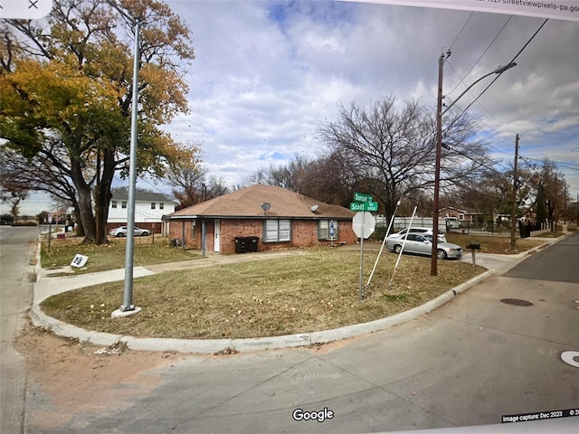 view of front of home featuring brick siding and a front lawn