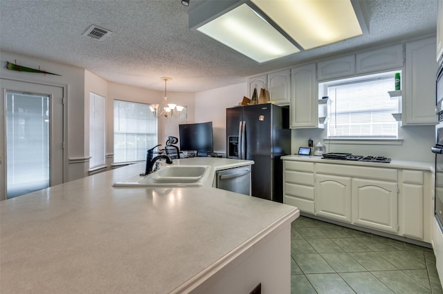 kitchen featuring visible vents, white cabinets, appliances with stainless steel finishes, light countertops, and pendant lighting