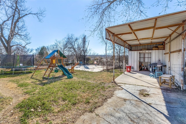 view of yard with a trampoline, a playground, a patio, and a carport