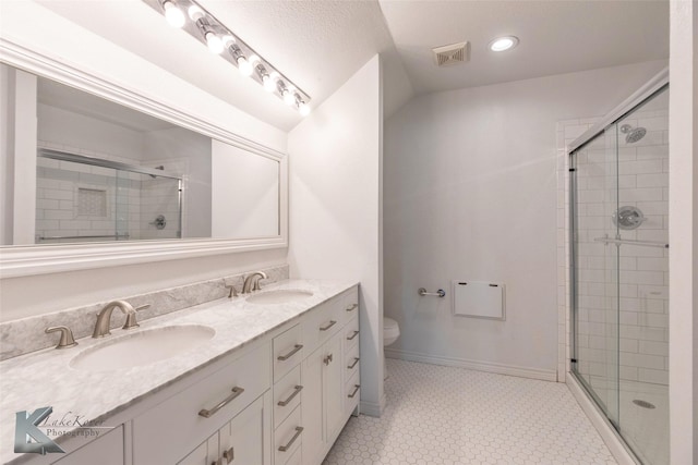 bathroom with toilet, a stall shower, a sink, and visible vents