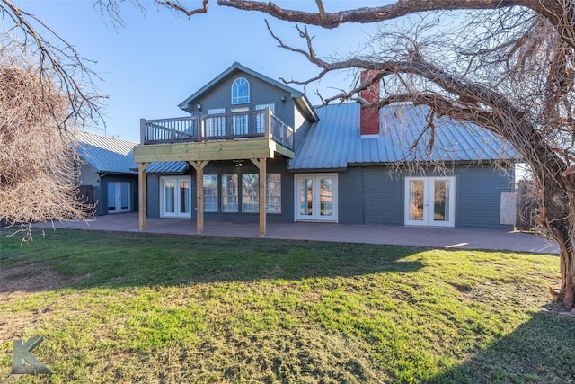 rear view of house with metal roof, a yard, french doors, and a patio