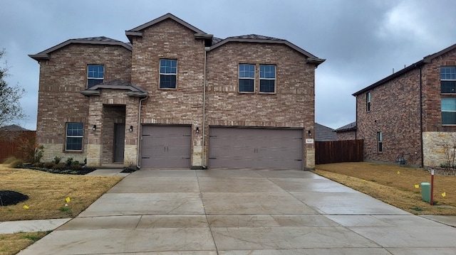 traditional-style house featuring an attached garage, a front lawn, concrete driveway, and brick siding