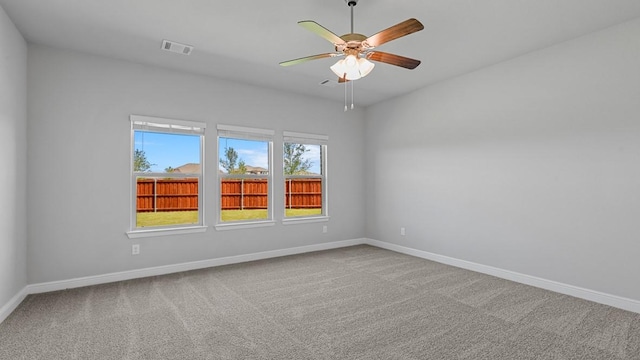 spare room featuring a ceiling fan, visible vents, baseboards, and carpet flooring