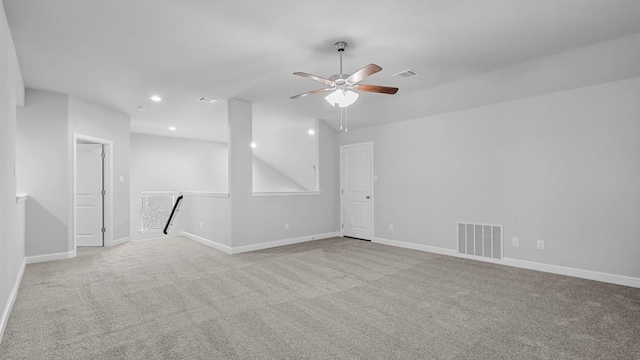 spare room with light carpet, recessed lighting, visible vents, and baseboards