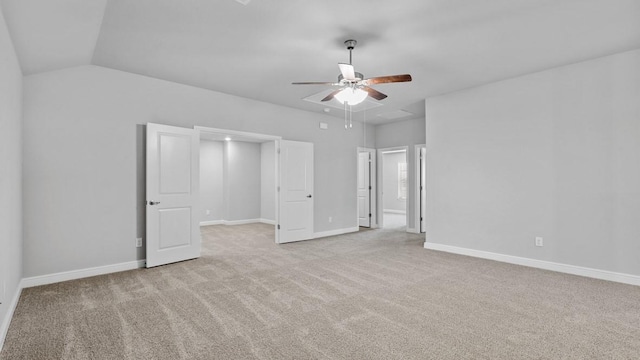 unfurnished bedroom with lofted ceiling, baseboards, a ceiling fan, and light colored carpet