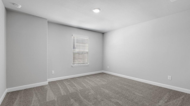 empty room featuring carpet floors and baseboards