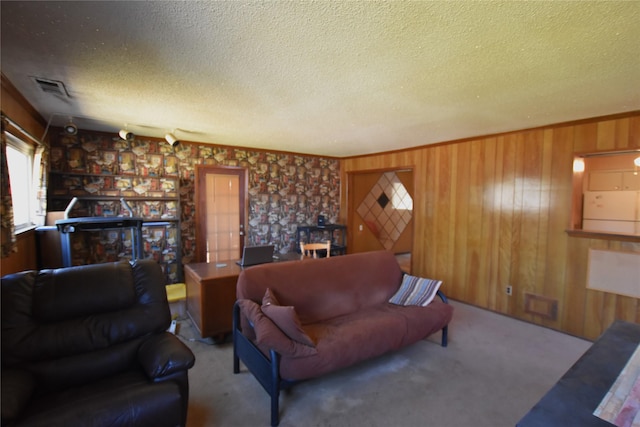 carpeted living area featuring wooden walls, visible vents, a fireplace, and a textured ceiling