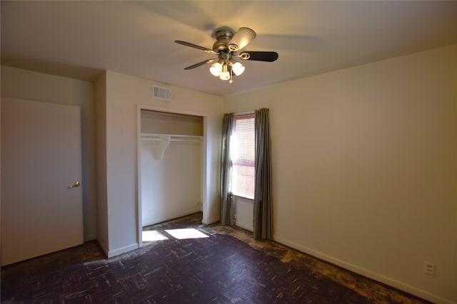 unfurnished bedroom with ceiling fan, a closet, visible vents, and baseboards