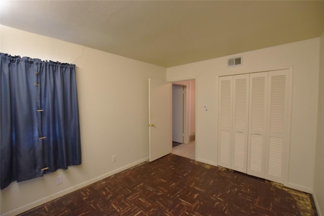 unfurnished bedroom with a closet, visible vents, and baseboards