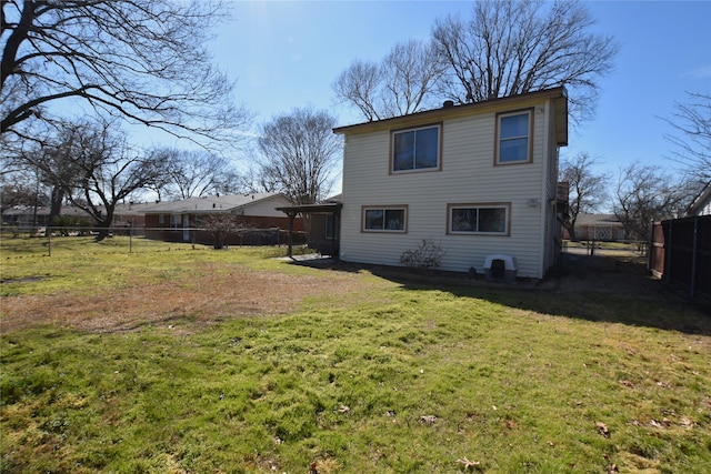 back of property with a fenced backyard and a lawn