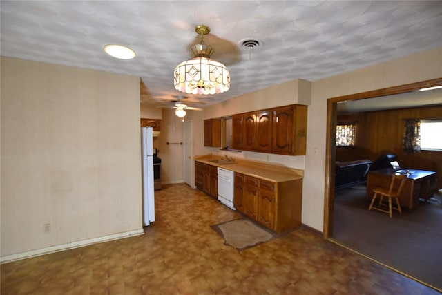 kitchen featuring white appliances, visible vents, brown cabinets, and light countertops