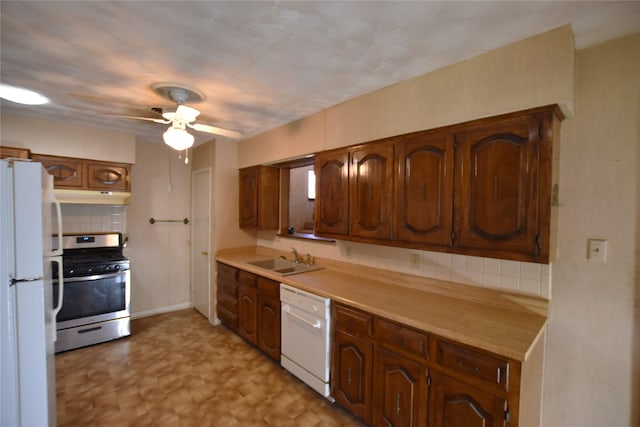 kitchen with under cabinet range hood, white appliances, a sink, light countertops, and backsplash