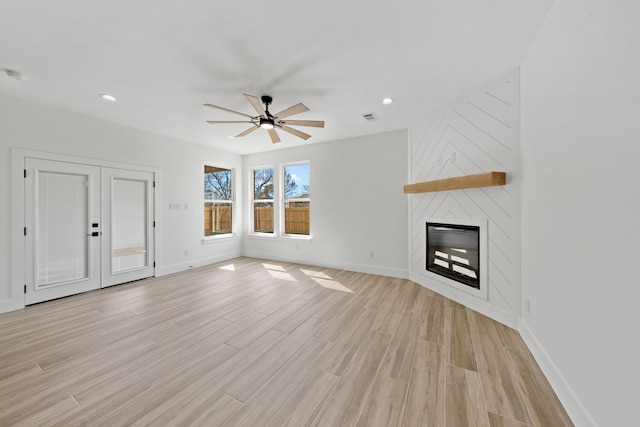 unfurnished living room featuring baseboards, ceiling fan, light wood-type flooring, a fireplace, and recessed lighting