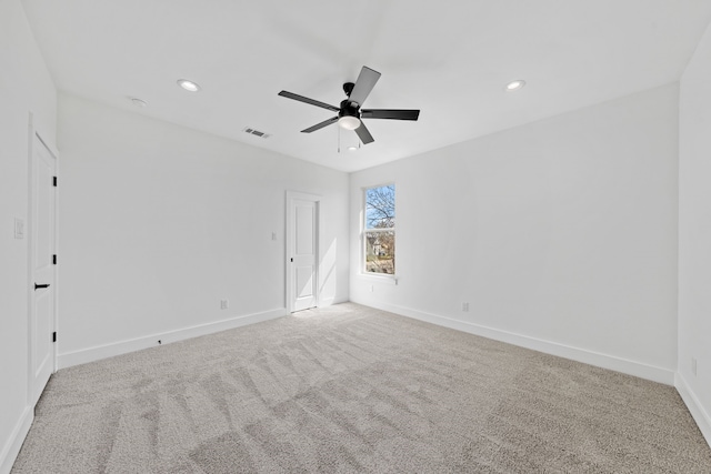 unfurnished room featuring a ceiling fan, visible vents, light carpet, and baseboards