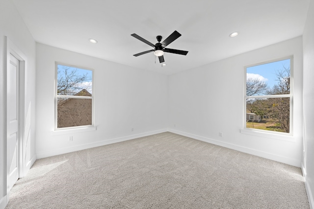 spare room with recessed lighting, baseboards, and light colored carpet