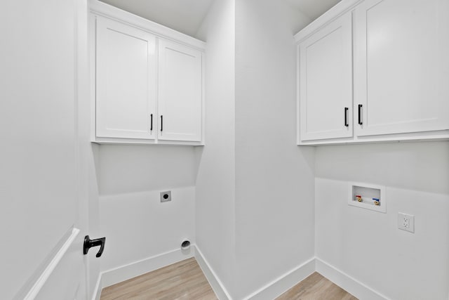 washroom featuring baseboards, light wood-style flooring, cabinet space, and hookup for an electric dryer