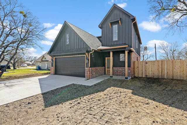 view of front of house featuring a shingled roof, concrete driveway, fence, board and batten siding, and brick siding