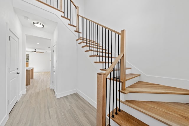 staircase featuring baseboards and wood finished floors