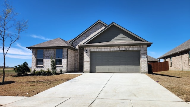 205 Tyler St, Grandview, TX 76050 - view of front facade with a garage, driveway, and brick siding