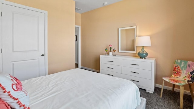 bedroom with baseboards, visible vents, and dark colored carpet