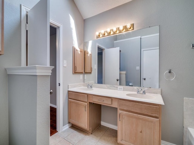 full bath featuring tile patterned floors, a sink, a bath, and double vanity