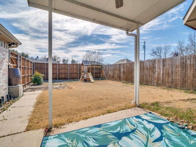 view of yard featuring a patio area, a fenced backyard, and a playground