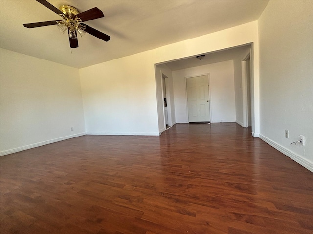 empty room featuring dark wood-style floors, ceiling fan, and baseboards