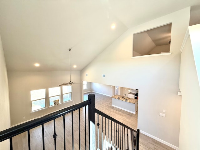 hall with high vaulted ceiling, recessed lighting, an upstairs landing, baseboards, and light wood finished floors