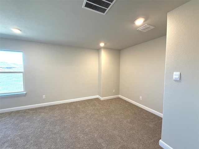 unfurnished room with carpet flooring, visible vents, and baseboards