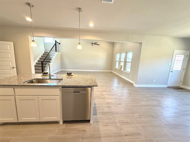 kitchen with hanging light fixtures, open floor plan, white cabinetry, a sink, and dishwasher