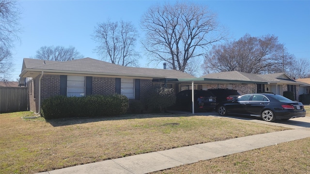 ranch-style home with a front yard, concrete driveway, brick siding, and an attached carport