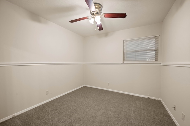 carpeted spare room featuring a ceiling fan and baseboards