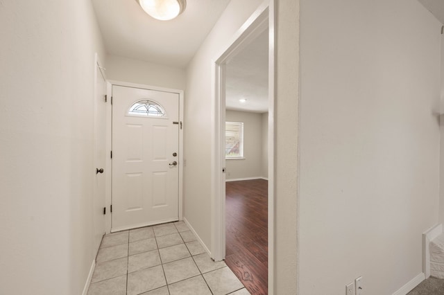 doorway featuring baseboards and light tile patterned floors