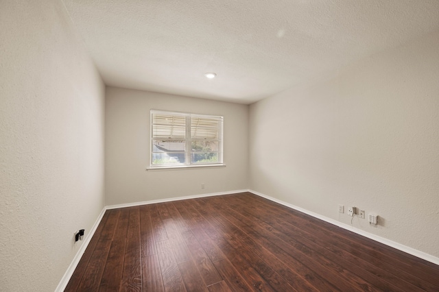 unfurnished room with baseboards and wood-type flooring