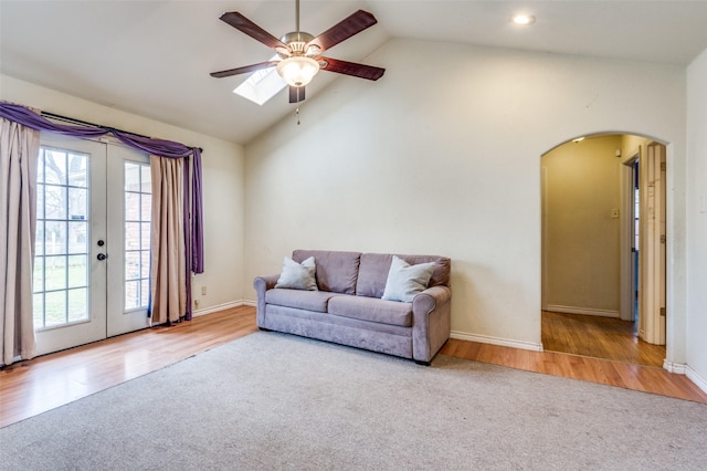 living area with light wood-type flooring, arched walkways, and french doors