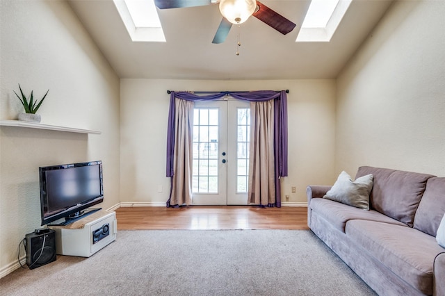 living room with lofted ceiling, ceiling fan, light carpet, baseboards, and french doors