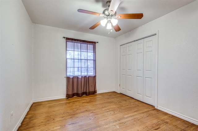 unfurnished bedroom with light wood-type flooring, a closet, ceiling fan, and baseboards