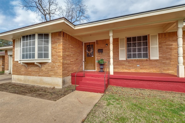 view of front of home with covered porch and brick siding