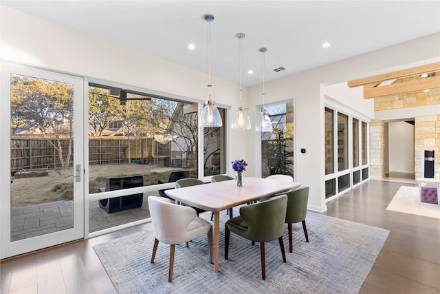 dining room featuring dark wood-style floors, recessed lighting, visible vents, and a fireplace