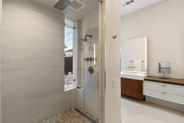 full bathroom featuring a stall shower, tile patterned flooring, vanity, and visible vents