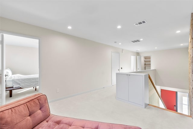 living area featuring recessed lighting, visible vents, light colored carpet, and an upstairs landing