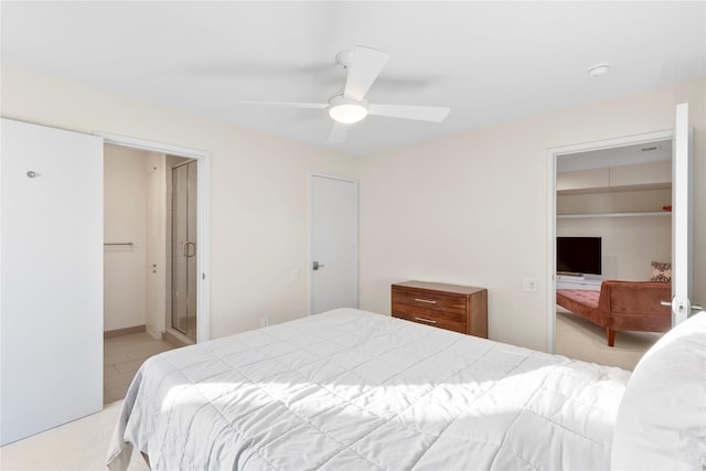 bedroom with light carpet, a closet, a walk in closet, and a ceiling fan