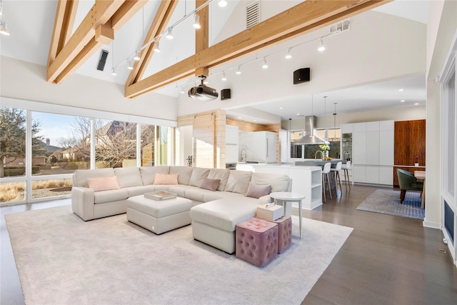 living area with high vaulted ceiling, beam ceiling, and wood finished floors