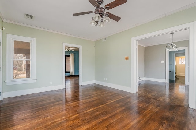 unfurnished room with dark wood-style floors, baseboards, visible vents, and crown molding