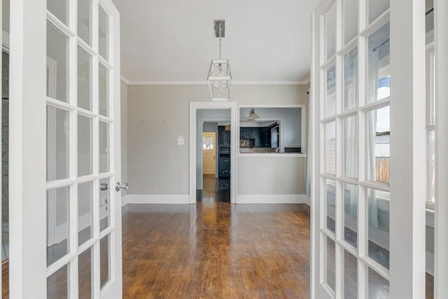 unfurnished dining area with baseboards, french doors, dark wood-style flooring, and crown molding