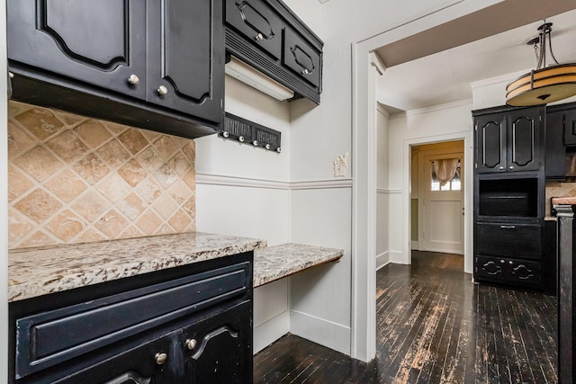 kitchen featuring dark cabinetry, ornamental molding, backsplash, and dark wood-style flooring