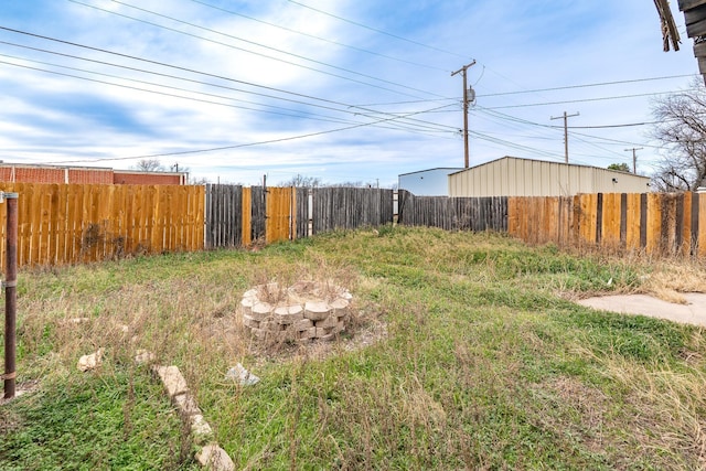 view of yard with an outdoor fire pit and fence