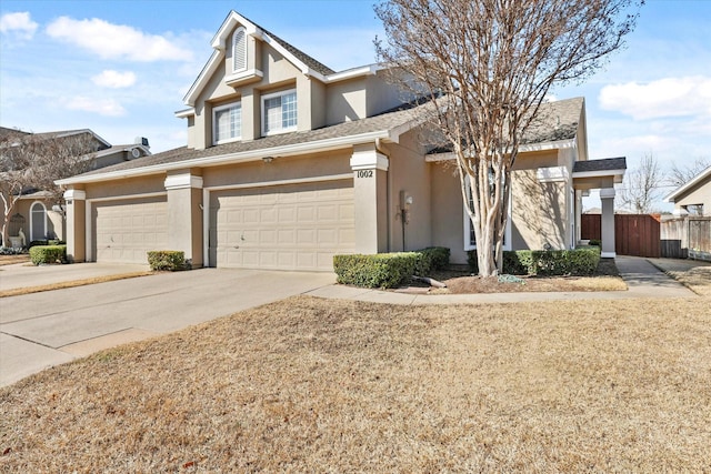 view of front facade featuring fence, concrete driveway, and stucco siding